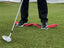 Golfer steht beim Chippen mit beiden Füßen auf dem EyeLine Golf Balance Rod – Balance-Training für konstanten Ballkontakt