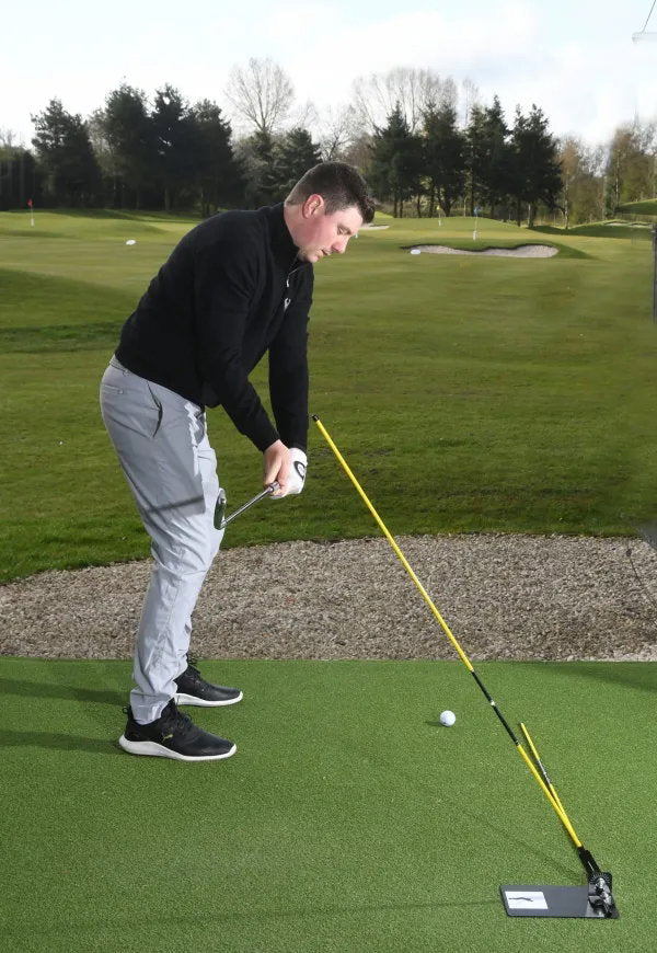 Golfer beim Ansprechen, der Stab der Swing Plate zeigt die Schwungebene entlang des Schafts